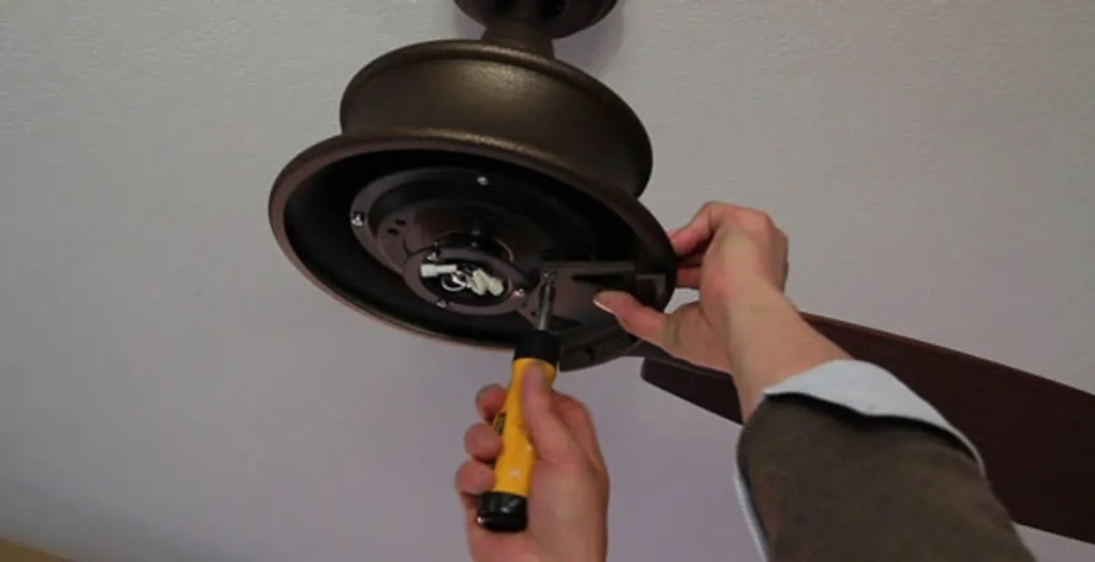 Electrician installing ceiling fan mounting bracket and fixture in Bloomington, IN