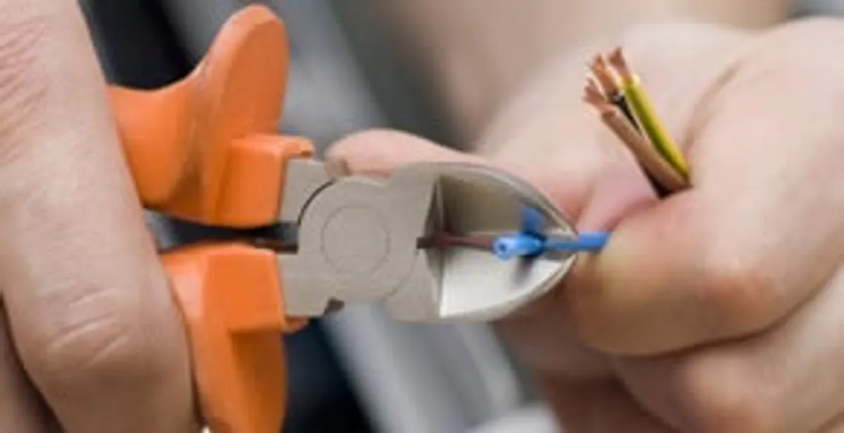 licensed electrician performing precise wire cutting and preparation during electrical service in Bloomington, IN
