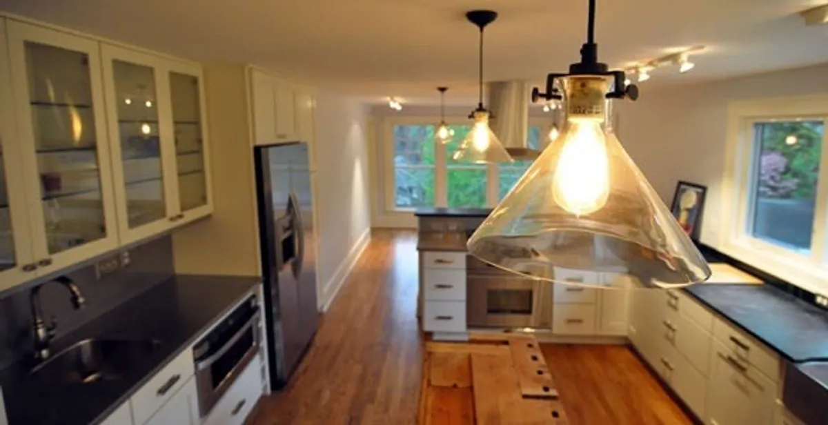 Residential electrician installing modern indoor light fixture in a home in Bloomington, IN